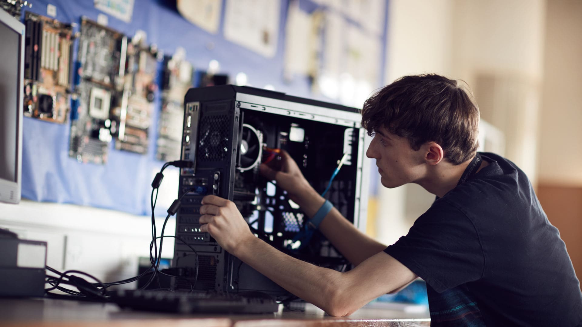 City of Bristol College student focusing on fixing a computer on an IT course