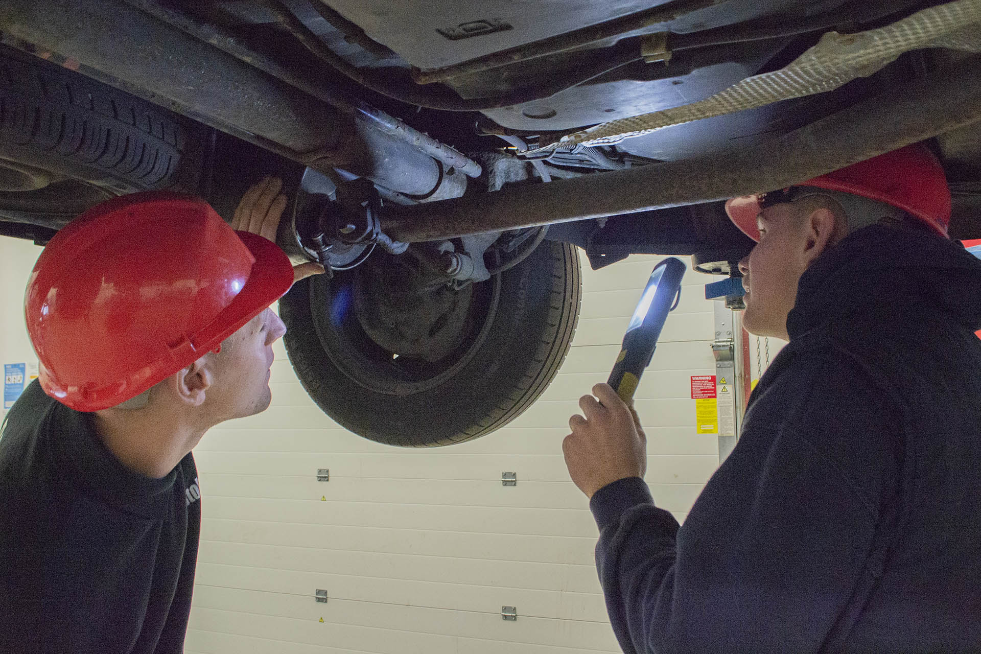 Light Vehicle. Students inspecting the underside of a vehicle