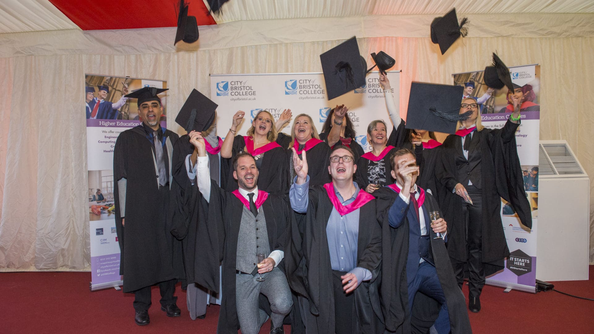 Graduation image of students throwing hats in air