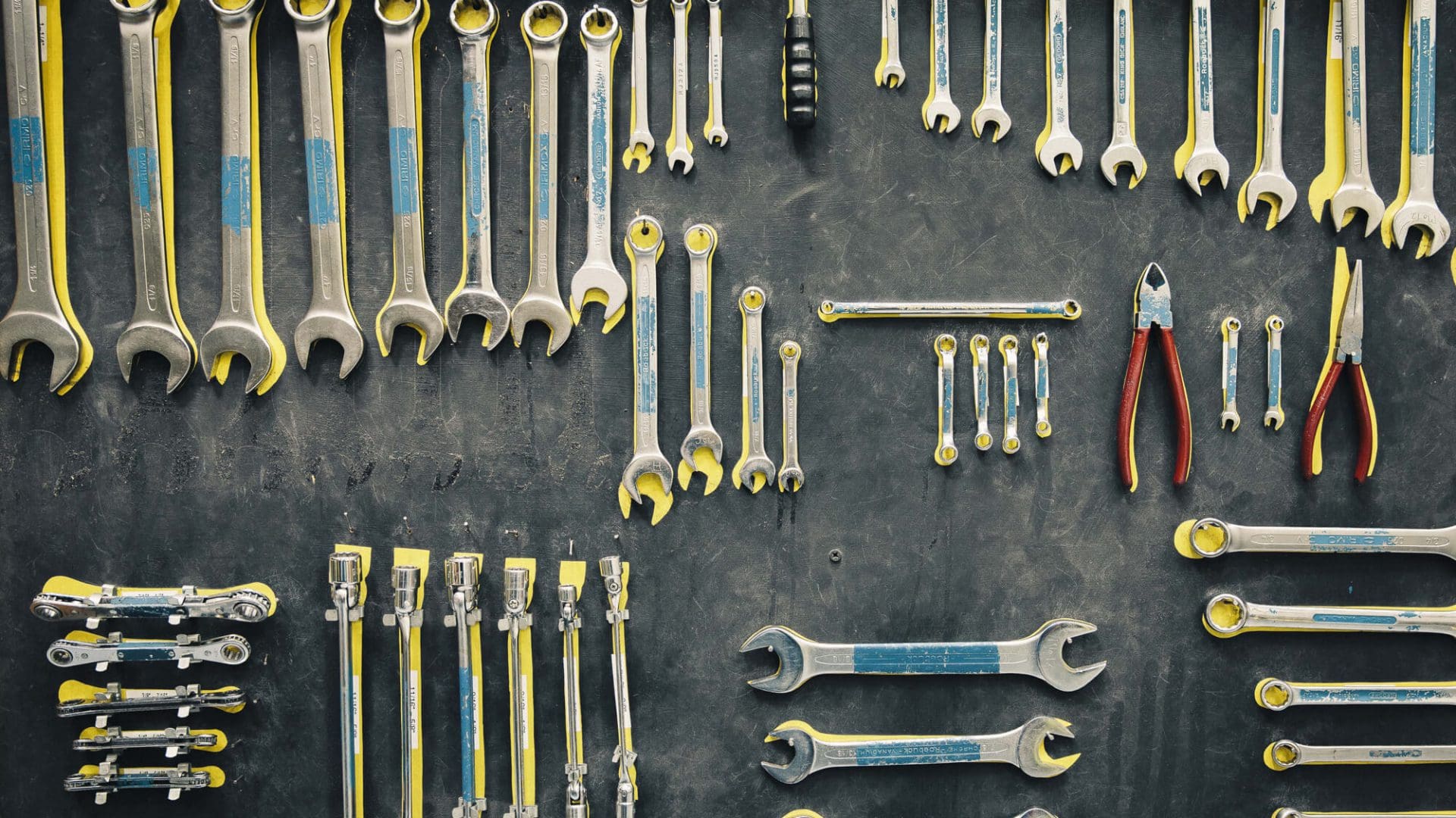 Wrenches and pliers hang up on a wall - tools for engineering courses in Bristol