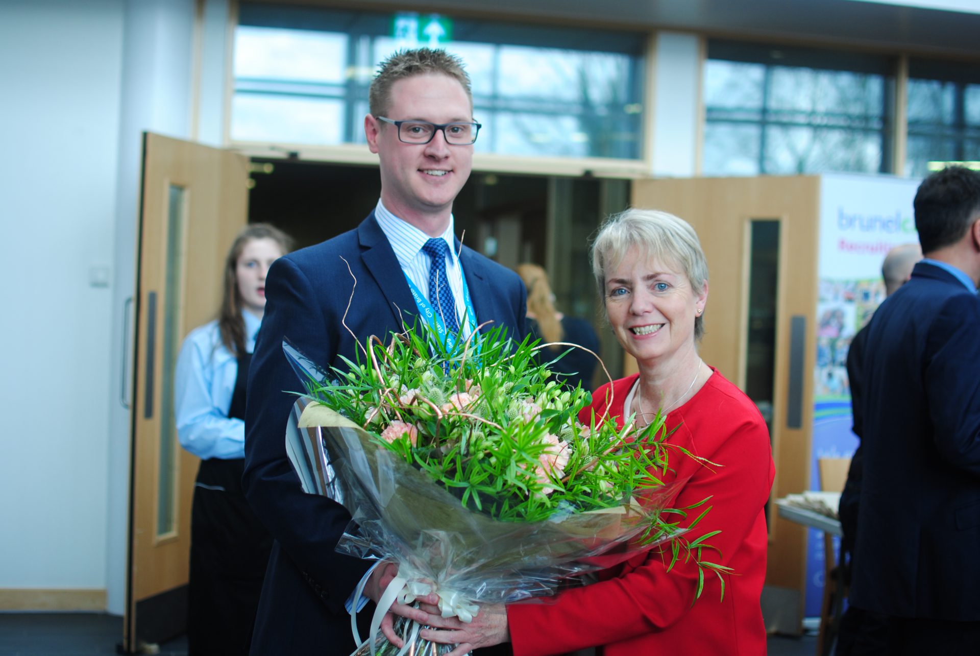 Bristol MP, Karin Smyth holding a bouquet of flowers with Lee Probert, Principal and Chief Executive