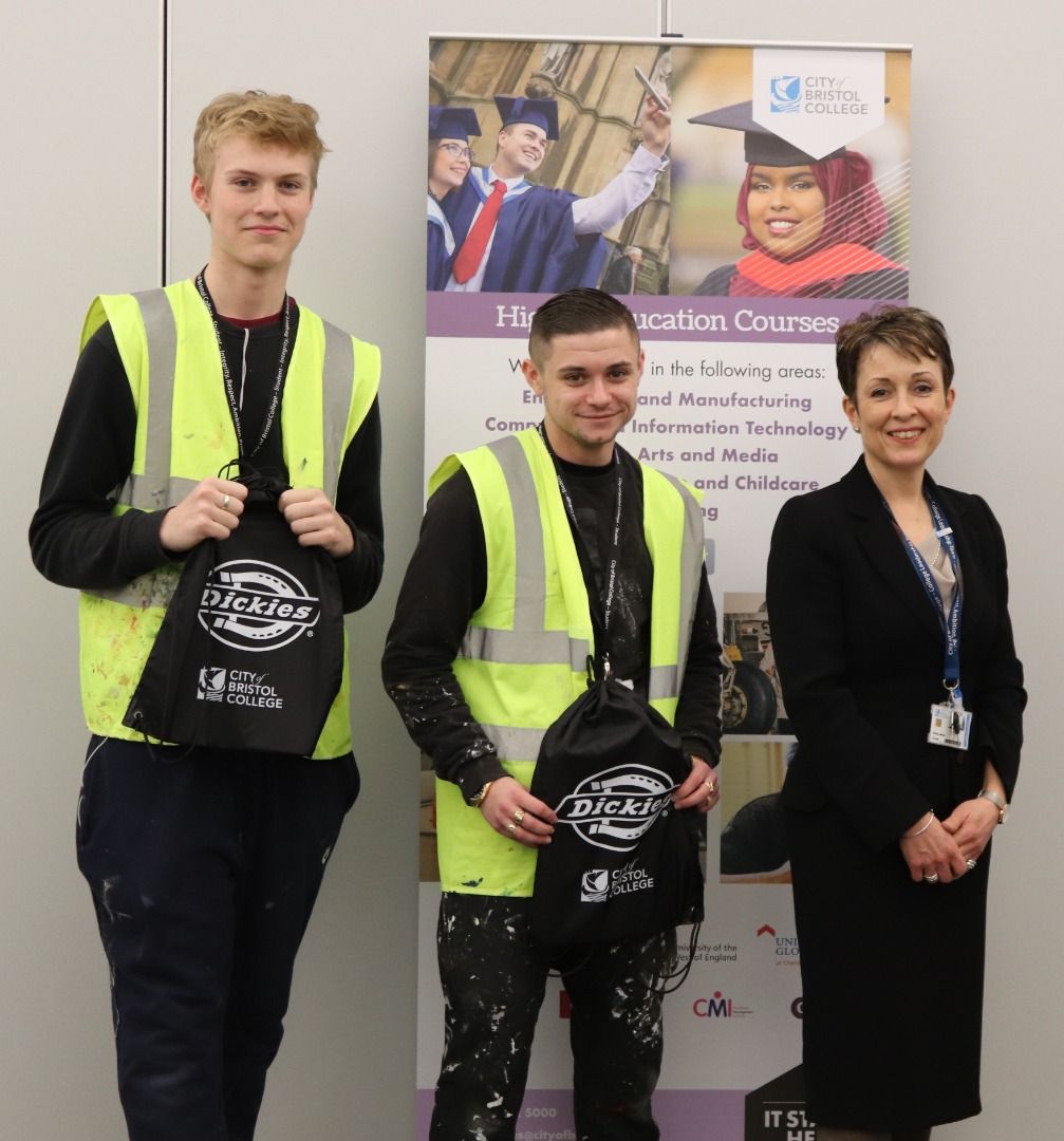 Two students pose with Emma Jarman, holding bags branded with 'Dickies'