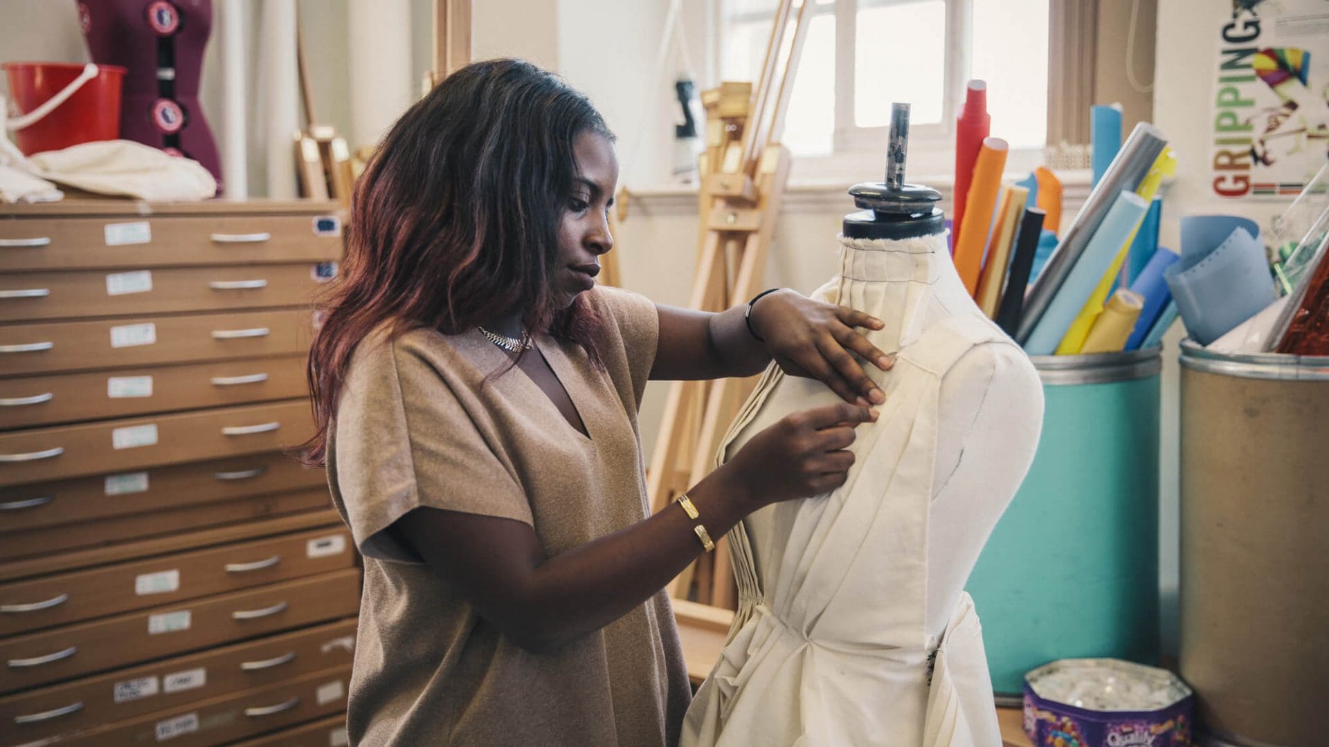 Fashion student works on a dress in an art-room in evening, part-time class