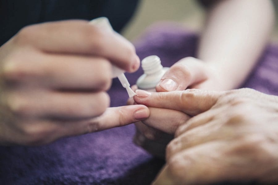 Nails student, Brittany Evans, paints a clients nails