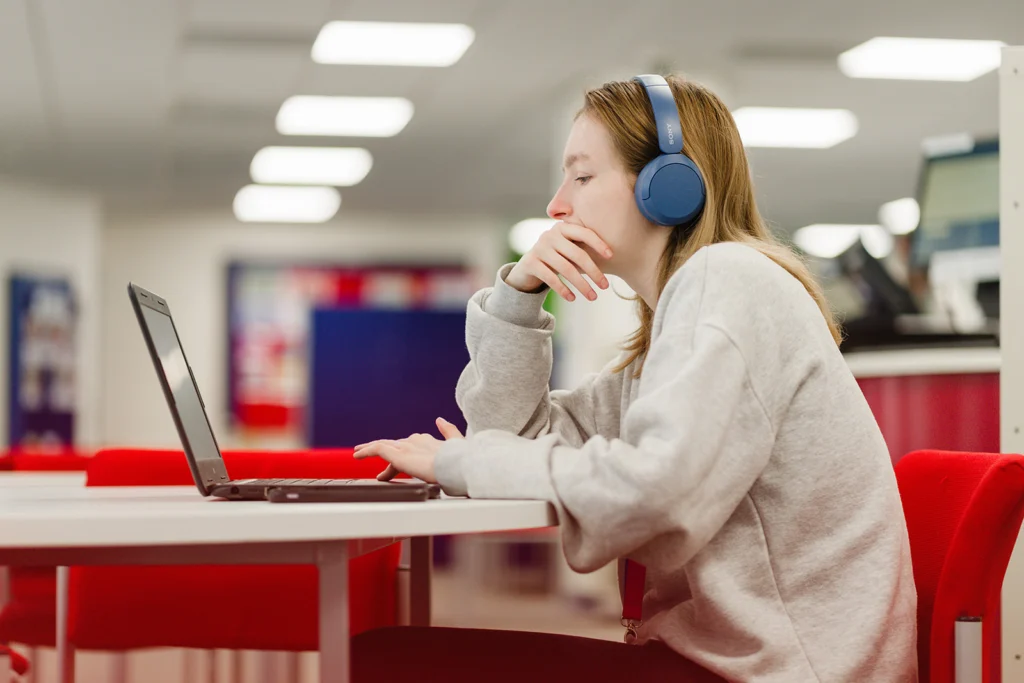 student using a laptop wearing headphones