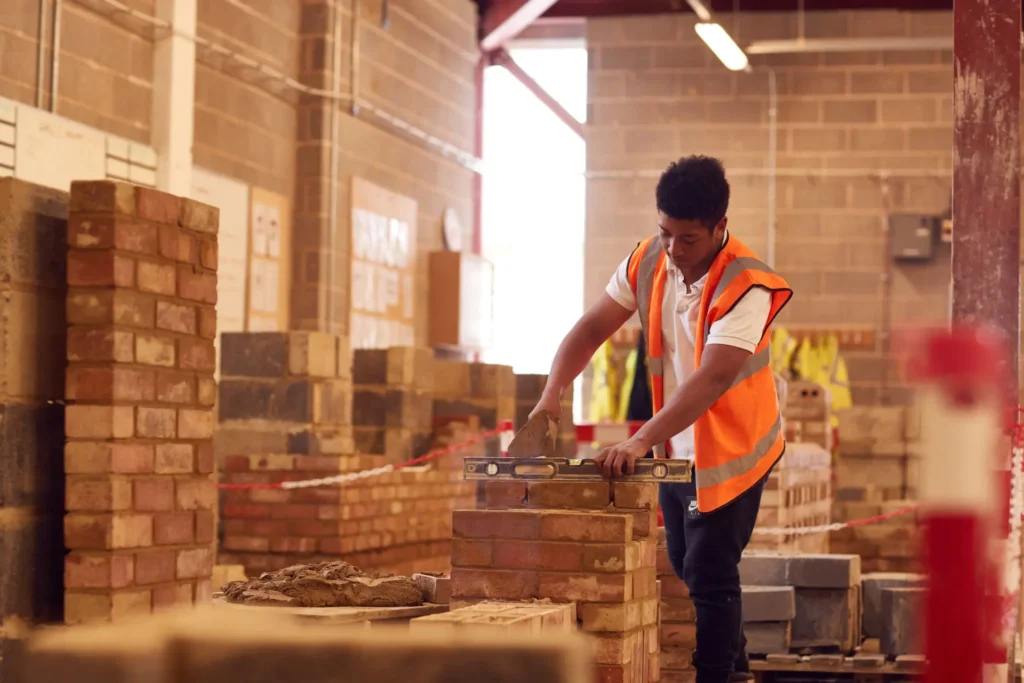 Construction student laying bricks