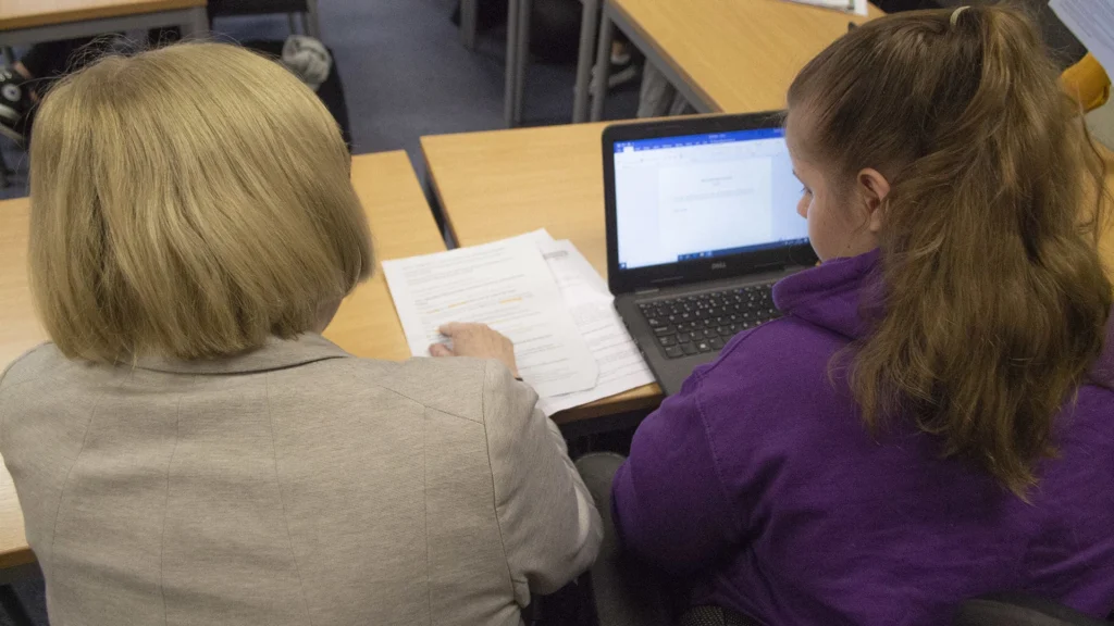 Teacher going through a paper with a student