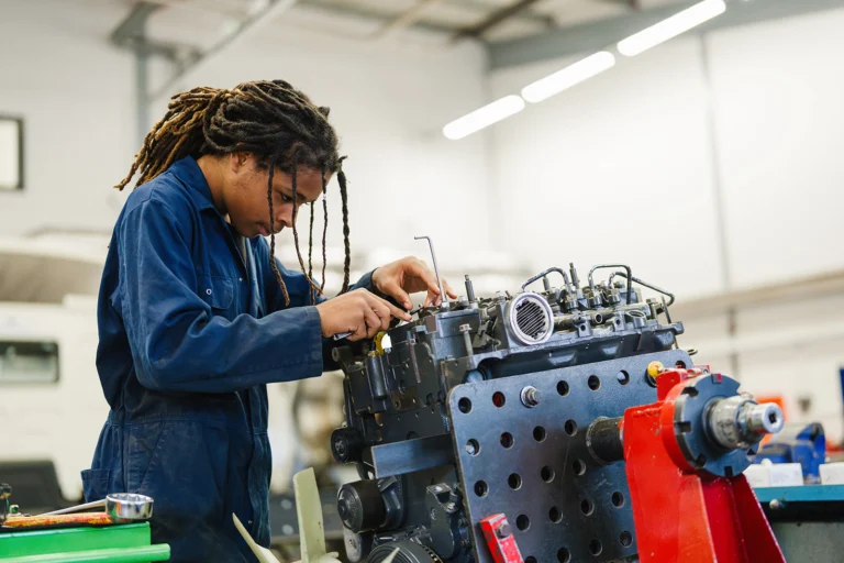 student working on a car engine