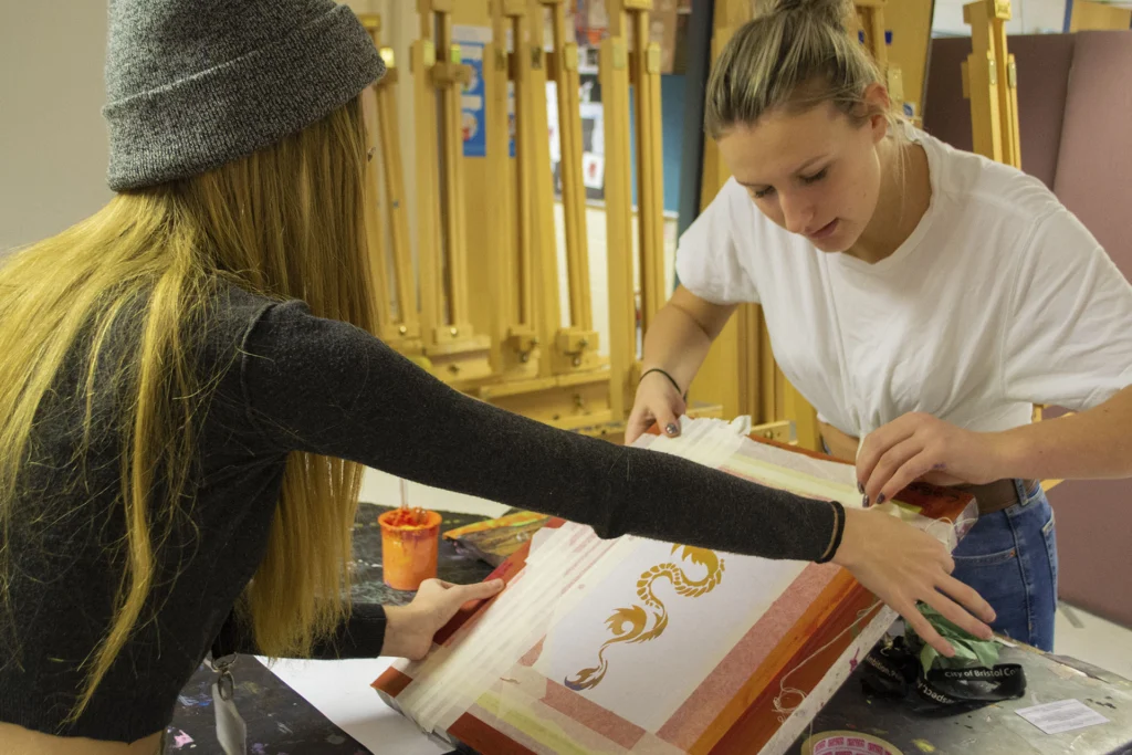 Two students making art
