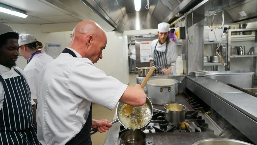 Catering and Hospitality Students pictured with a guest chef in the kitchen at the College Green Centre.