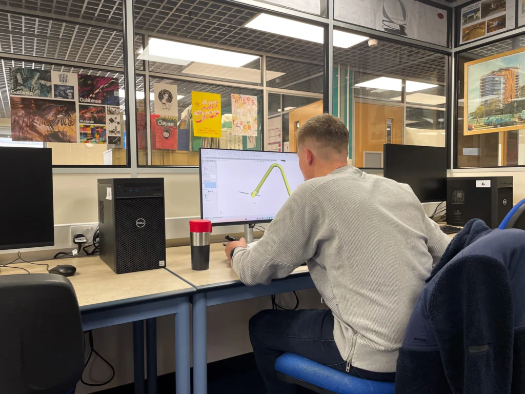 A student using CAD software on a computer.