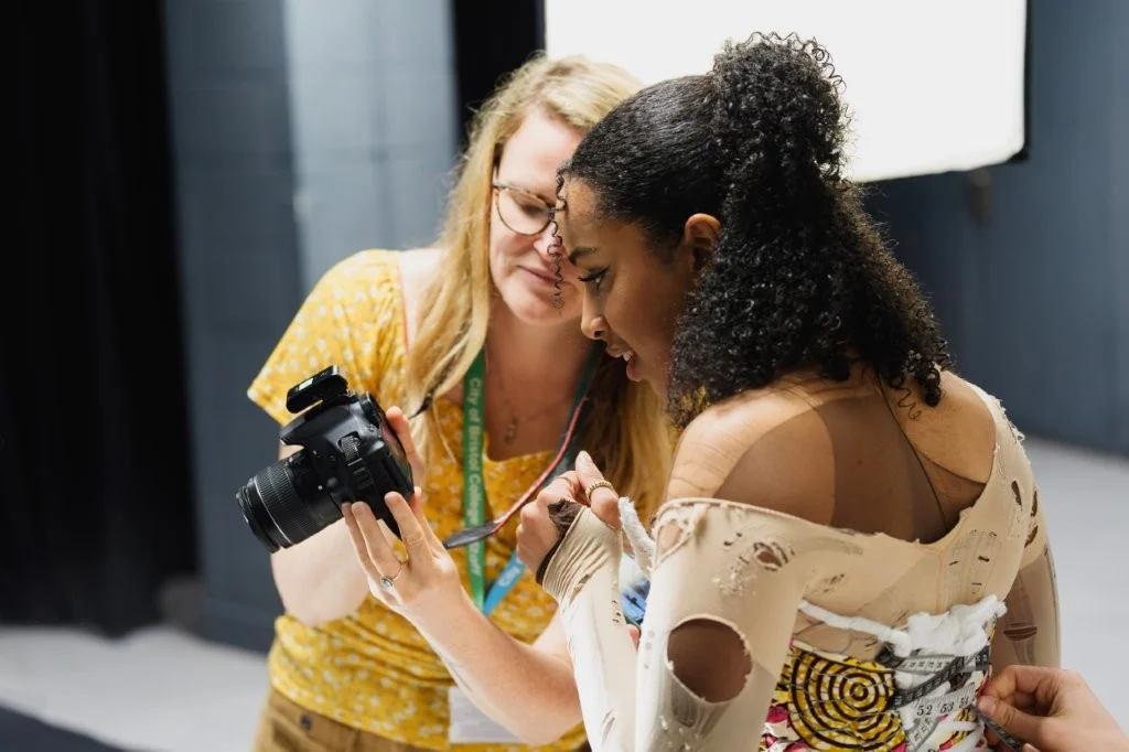 Photography student and teacher looking at a DSLR camera 