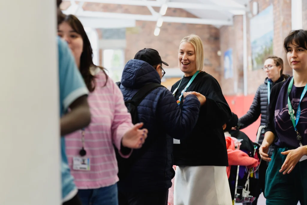 A older person is smiling and dancing with one of the students