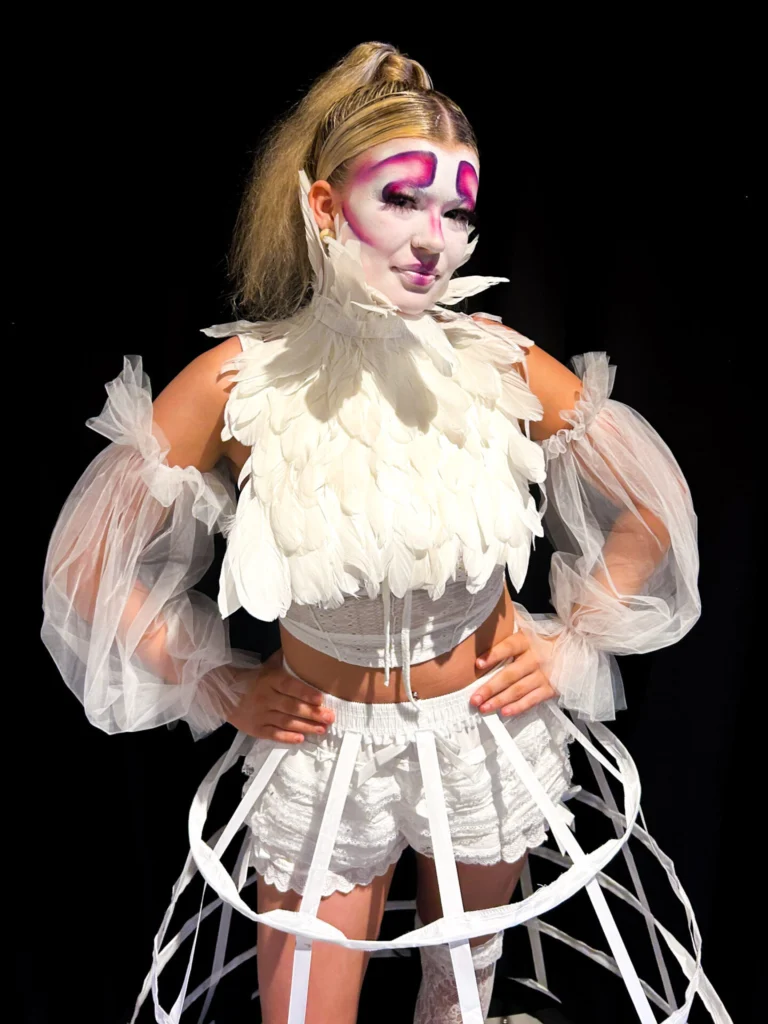 Student models creative work from Make up and Hair students at regional competition.