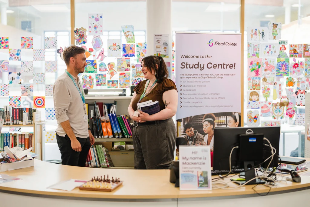 two staff members socialising in library
