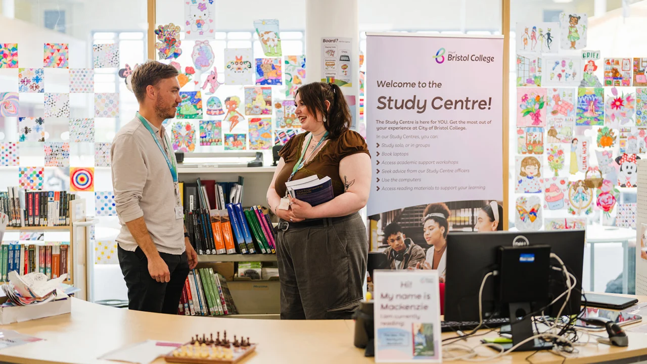 two staff members socialising in library