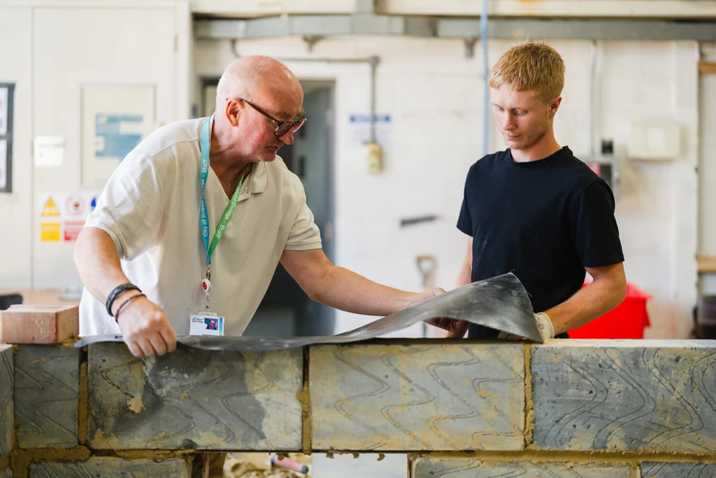 teacher showing student how to layer bricks