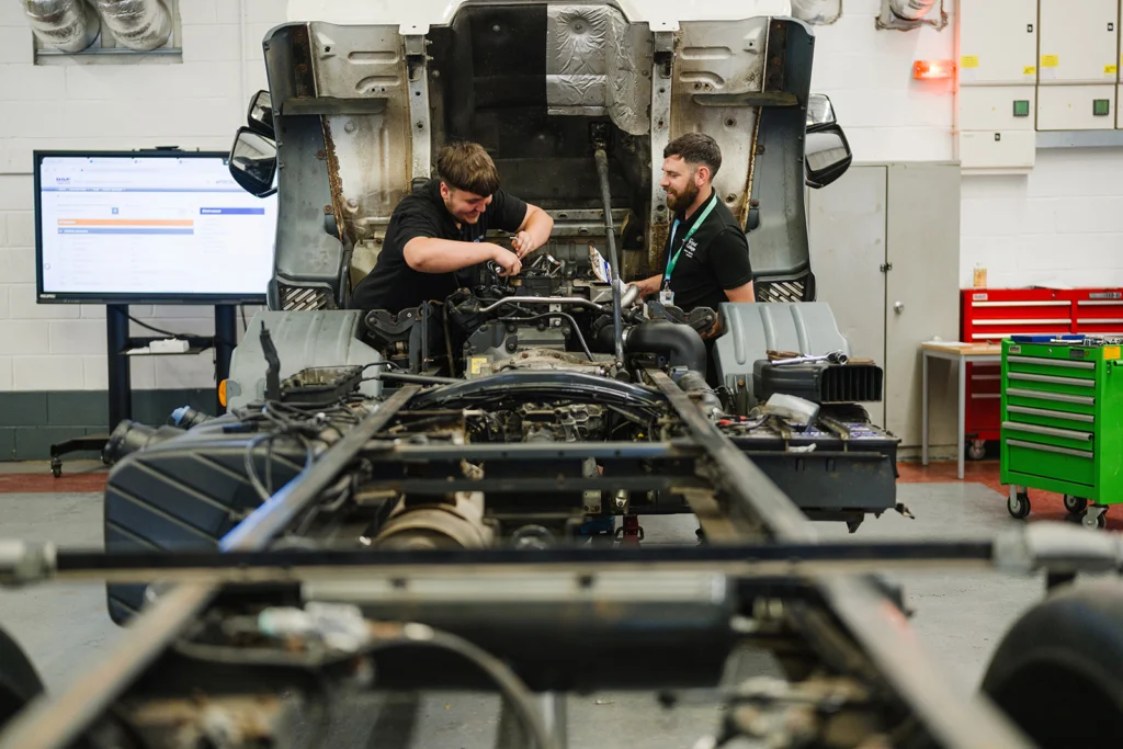 two students working on a lorry