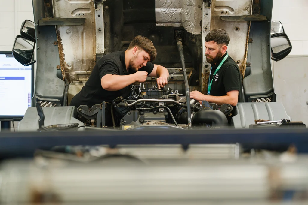 students working on a lorry