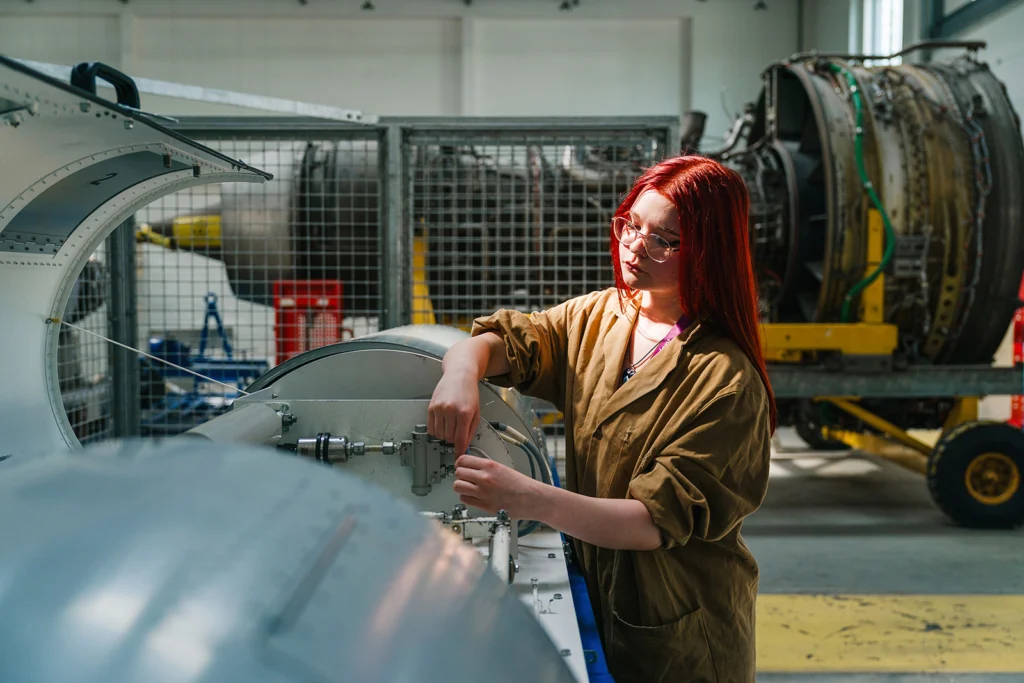 female student working on aircraft engine