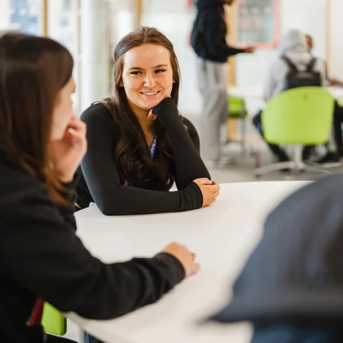 Students sat at a a table smiling