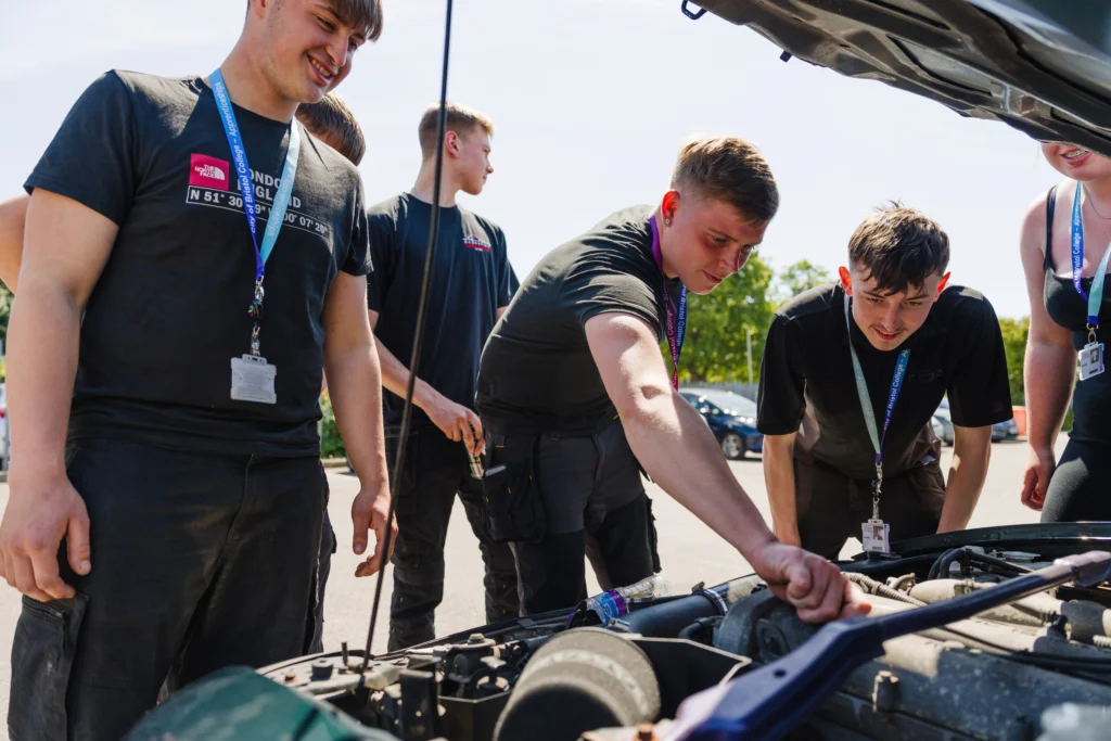 Motor vehicle students checking a car's motor
