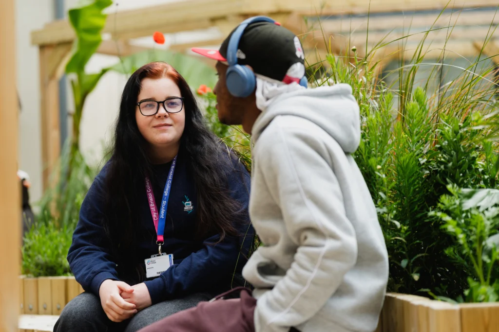 Two students sat at the college green's open area