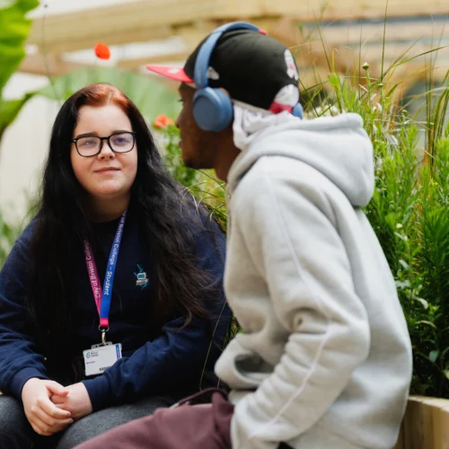 Two students sat at the college green's open area