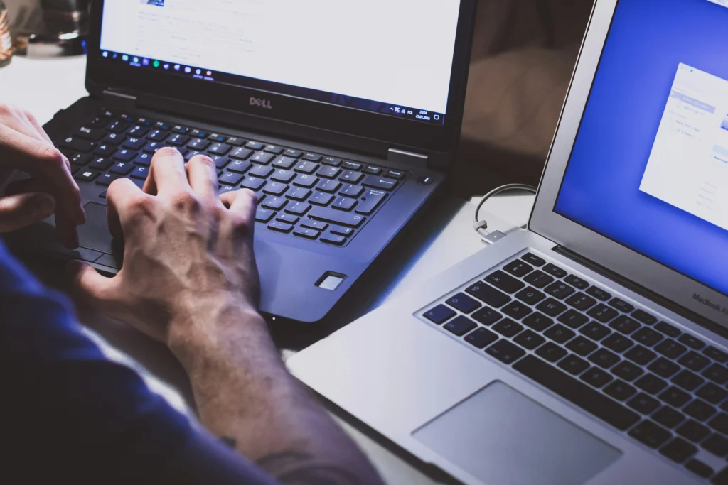 man using two laptops