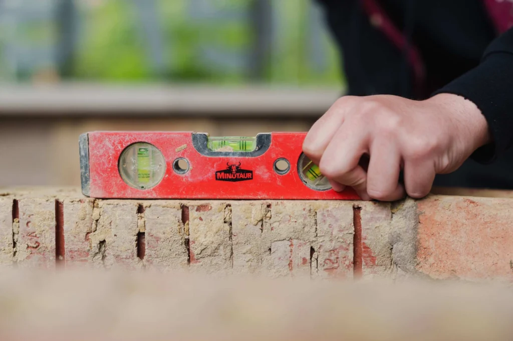 Student using a torpedo level on a brick